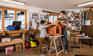 Kind mit Vater in Werkstatt
